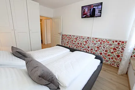 Schlafzimmer mit Doppelbett (1,80 m x 2,00 m), verstellbaren Lattenrosten, Nachttischablagen, Kleiderschrank sowie ein TV