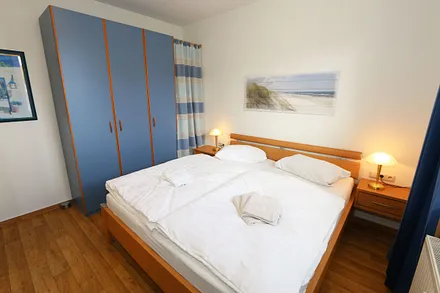 Schlafzimmer mit Doppelbett und Kleiderschrank