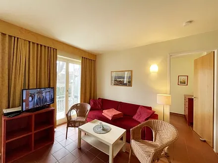 Wohnbereich mit komfortabler Schlafcouch (1,60m x 2,00m), Leselampe und LED Fernseher