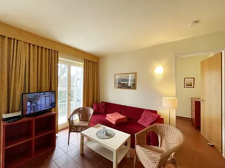 Wohnbereich mit komfortabler Schlafcouch (1,60m x 2,00m), Leselampe und LED Fernseher