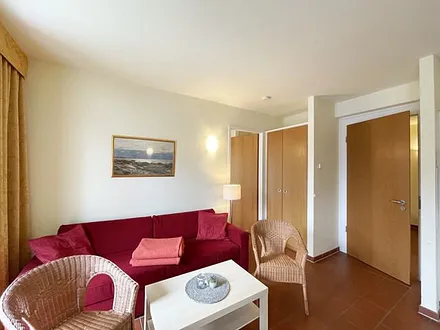 Wohnbereich mit komfortabler Schlafcouch (1,60m x 2,00m), Leselampe und LED Fernseher