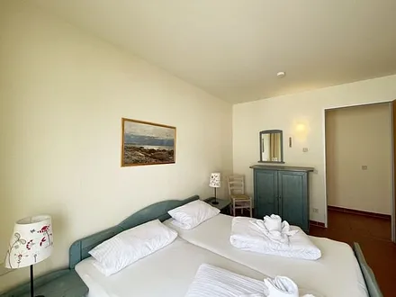 Schlafzimmer mit Doppelbett mit 7-Zonen Matratzen (2 x 0,90 m x 2,00 m), Kleiderschrank und Kommode mit Spiegel