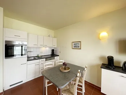 Küchenzeile mit Cerankochfeld, Spülmaschine, Backofen, Kaffeemaschine, Wasserkocher, Toaster, Kühlschrank und allen wichtigen Küchenutensilien