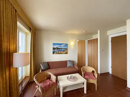 Wohnbereich mit komfortabler Schlafcouch (1,60m x 1,95m), Leselampe und LED Fernseher