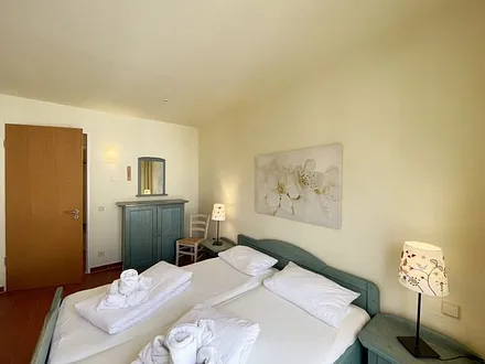 Schlafzimmer mit Doppelbett, 7-Zonen Matratzen (2 x 0,90 m x 2,00 m), Kleiderschrank und Kommode mit Spiegel