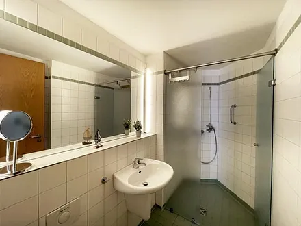 Badezimmer mit ebenerdiger Dusche, WC, Waschbecken und Fön