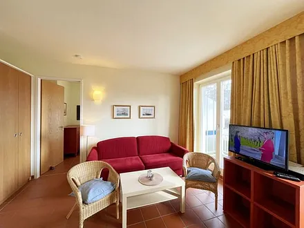 Wohnbereich mit komfortabler Schlafcouch (1,60m x 2,00m), Leselampe und LED Fernseher