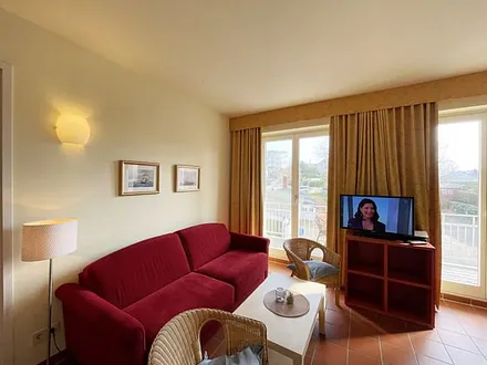 Wohnbereich mit komfortabler Schlafcouch (1,60m x 2,00m), Leselampe und LED Fernseher