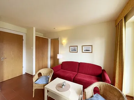 Wohnbereich mit komfortabler Schlafcouch (1,60m x 2,00m), Leselampe und LED Fernseher