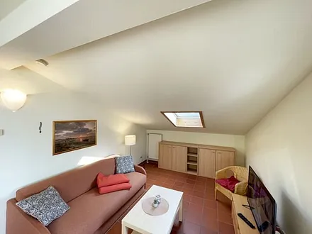 Wohnbereich mit komfortabler Schlafcouch (1,60m x 1,95m), Leselampe und LED Fernseher