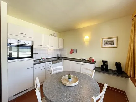 Küchenzeile mit Cerankochfeld, Spülmaschine, Backofen, Kaffeemaschine, Wasserkocher, Toaster, Kühlschrank und allen wichtigen Küchenutensilien