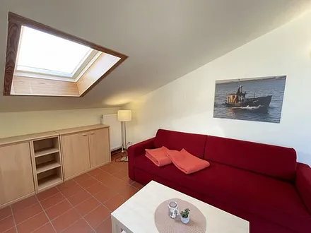 Wohnbereich mit komfortabler Schlafcouch (1,60m x 2,00m), Leselampe und LED Fernseher