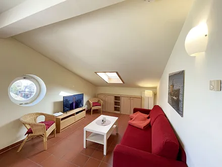 Wohnbereich mit komfortabler Schlafcouch (1,60m x 2,00m), Leselampe und LED Fernseher