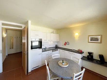 Küchenzeile mit Cerankochfeld, Spülmaschine, Backofen, Kaffeemaschine, Wasserkocher, Toaster, Kühlschrank und allen wichtigen Küchenutensilien