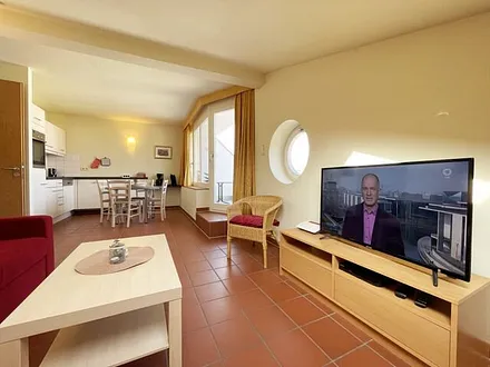 Wohnbereich mit komfortabler Schlafcouch (1,60m x 2,00m), Leselampe und LED Fernseher