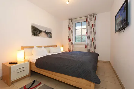 Schlafzimmer mit Doppelbett und TV