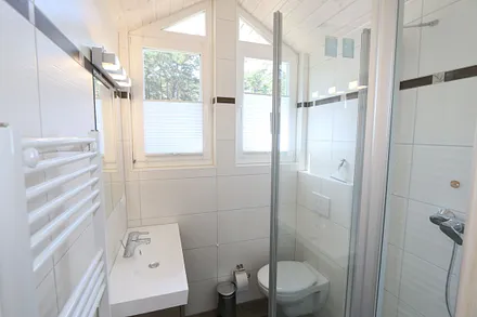 Badezimmer mit Dusche, Waschplatz und WC