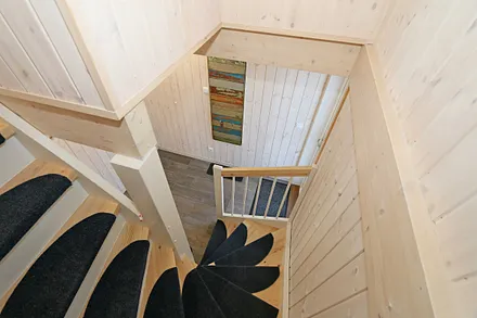 Zugang zum Obergeschoss durch eine Kiefernholztreppe 
