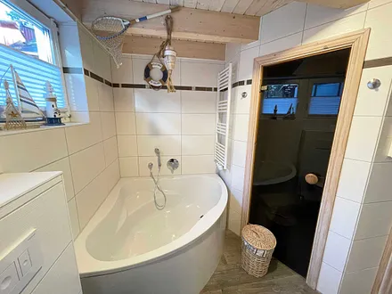 Bad mit Dusche, Waschplatz, WC, Waschmaschine, Kosmetikspiegel, Fön, Wellnesswanne und Sauna