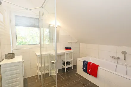 Badezimmer mit Badewanne und Dusche