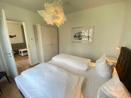 Schlafzimmer mit einem Boxspringbett (1,80 m x 2,00 m), Beistelltischen mit Nachtlicht, einem Kleiderschrank sowie lichtdichte Vorhänge und Insektenschutzgitter