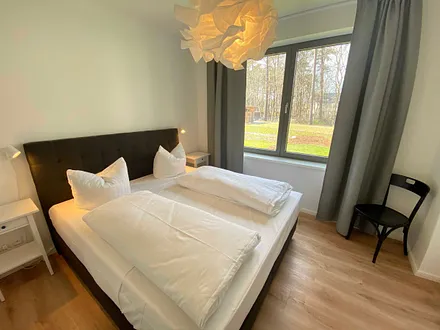 Schlafzimmer mit einem Boxspringbett (1,80 m x 2,00 m), Beistelltischen mit Nachtlicht, einem Kleiderschrank sowie lichtdichte Vorhänge und Insektenschutzgitter