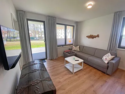 Wohnbereich mit bequemer Couch (1,40 m x 2,00 m), mobilem Couchtisch sowie einen Smart-TV mit Sono-Soundbar