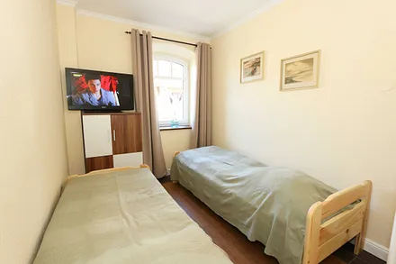 Schlafzimmer mit 2 Liegen (je 0,70 m x 1,80 m) - zu einem Doppelbett zusammenstellbar, Kommode und Flachbild-TV