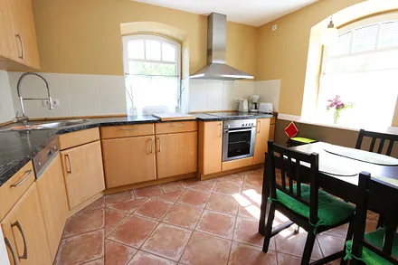 Küche mit Geschirrspüler, Backofen mit Ceranfeld, Abzugshaube, Kühlschrank mit Eisfach, Mikrowelle, Kaffeemaschine, Toaster, Wasserkocher und diversen Küchenutensilien