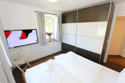 Schlafzimmer mit Doppelbett (1,80 m x 2,00 m), verstellbaren Lattenrosten, großem Kleiderschrank und Flachbild-TV