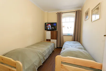 Schlafzimmer mit 2 Liegen (je 0,70 m x 1,80 m) - zu einem Doppelbett zusammenstellbar, Kommode und Flachbild-TV