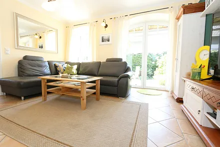 gemütlicher Wohnbereich mit einer großen Couchecke, Couchtisch, Leselampe, Sideboard, Flachbild-TV und Mini-Stereo-Anlage