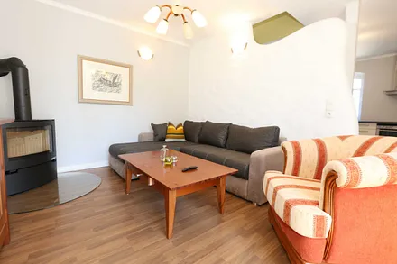 Wohnbereich mit großer Couchecke, Couchtisch, Leselampe, Sideboard, Smart-TV und Mini-Stereo-Anlage