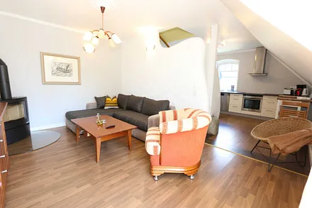 Wohnbereich mit großer Couchecke, Couchtisch, Leselampe, Sideboard, Smart-TV und Mini-Stereo-Anlage