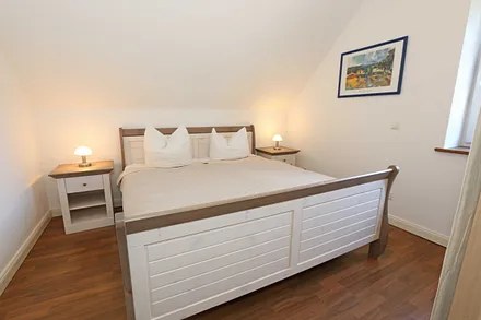 Schlafzimmer mit Doppelbett (1,80 m x 2,00 m), verstellbaren Lattenrosten, Nachttischablagen, Kleiderschrank, Verdunklungsmöglichkeit und Smart-TV