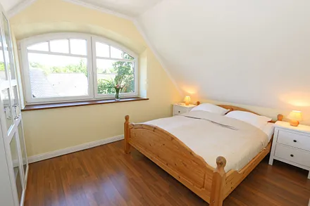 Schlafzimmer mit Doppelbett (1,60 m x 2,00 m), verstellbaren Lattenrosten, Nachttischablagen, Kleiderschrank, Verdunklungsmöglichkeiten und Smart-TV