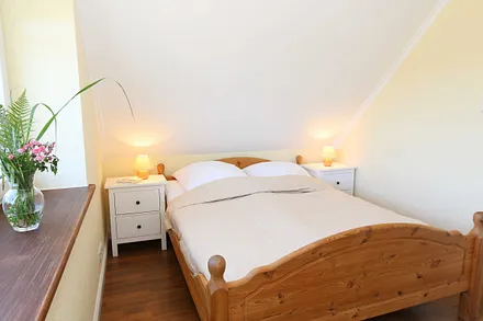Schlafzimmer mit Doppelbett (1,60 m x 2,00 m), verstellbaren Lattenrosten, Nachttischablagen, Kleiderschrank, Verdunklungsmöglichkeiten und Smart-TV