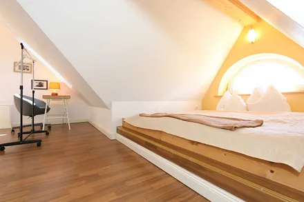 Schlafzimmer (unter Dachschrägen) mit Doppelbett (1,80 m x 2,00 m), Kleiderschrank, Verdunklungsmöglichkeiten und einem Schreibtisch