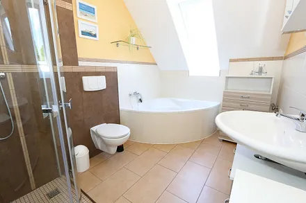 großzügiges Tageslicht-Bad mit Eckbadewanne, Dusche, WC, Waschtisch und Fön