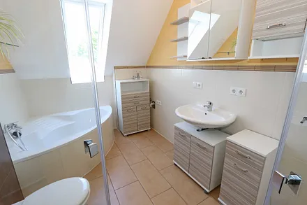 großzügiges Tageslicht-Bad mit Eckbadewanne, Dusche, WC, Waschtisch und Fön