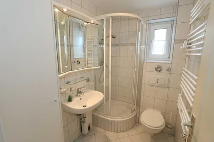 Badezimmer mit Waschtisch, WC, Fön und Dusche