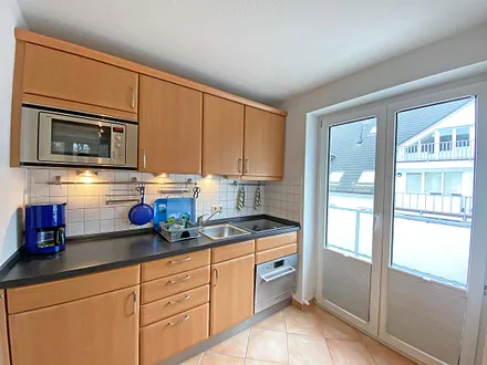 Küchenzeile verfügt über Kühlschrank mit Eisfach, Induktionsfeld, Geschirrspüler, Mikrowelle mit Grillfunktion, Wasserkocher, Kaffeemaschine, Toaster und diversen Küchenutensilien