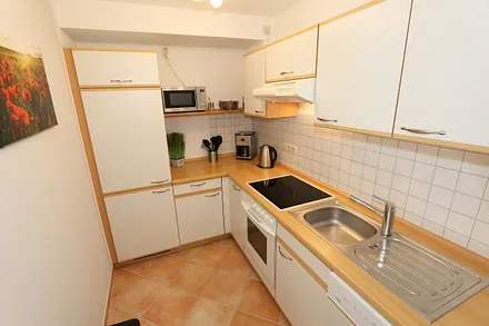 Küche mit Geschirrspüler, Cerankochfeld, Backofen, Kühlschrank mit Gefrierfächer, Mikrowelle, Kaffeemaschine, Senseopad-Maschine, Wasserkocher, Toaster sowie diverse Küchenutensilien