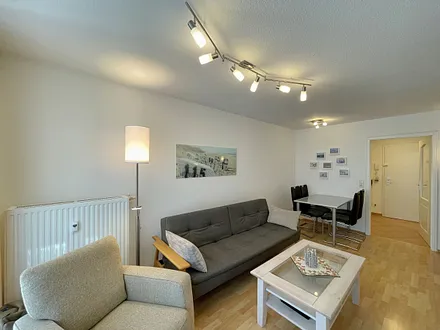 Wohnbereich mit gemütlicher Couch, Couchtisch, kleiner Anrichte, Leselampe, LCD-Flachbildschirm, Blu-Ray-Player sowie Radio/CD-Player