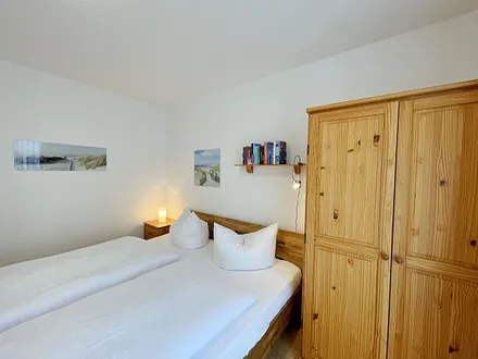 Schlafzimmer mit Doppelbett (1,80 m x 2,00m / Kaltschaummatratzen), verstellbare Lattenroste, Nachttischablagen und zweitürigem Kleiderschrank