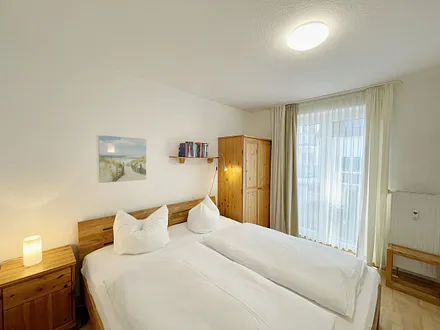 Schlafzimmer mit Doppelbett (1,80 m x 2,00m / Kaltschaummatratzen), verstellbare Lattenroste, Nachttischablagen und zweitürigem Kleiderschrank