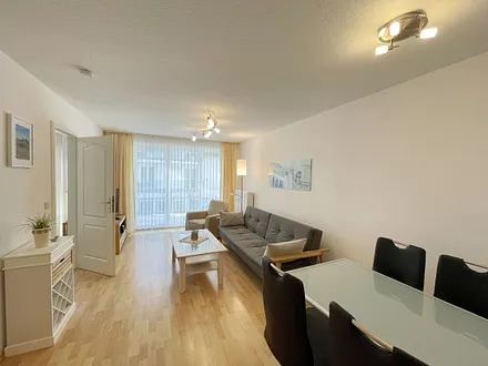 Wohnbereich mit gemütlicher Couch, Couchtisch, kleiner Anrichte, Leselampe, LCD-Flachbildschirm, Blu-Ray-Player sowie Radio/CD-Player