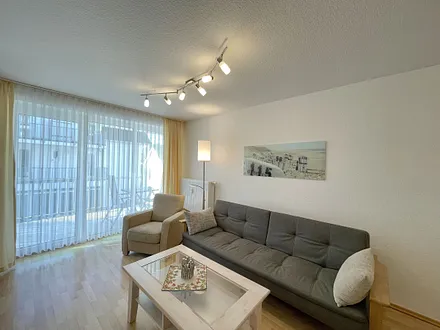 Wohnbereich mit gemütlicher Couch, Couchtisch, kleiner Anrichte, Leselampe, LCD-Flachbildschirm, Blu-Ray-Player sowie Radio/CD-Player