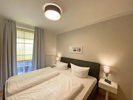 Schlafzimmer mit Echtleder-Doppelbett in Komforthöhe (2 x 0,90 m x 2,00 m), mit Nachttischablagen, Insektenschutzgittern, Verdunklungsmöglichkeit und einen großem Kleiderschrank