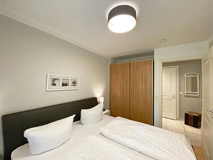 Schlafzimmer mit Echtleder-Doppelbett in Komforthöhe (2 x 0,90 m x 2,00 m), mit Nachttischablagen, Insektenschutzgittern, Verdunklungsmöglichkeit und einen großem Kleiderschrank